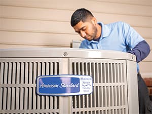 Professional AC Repair Service HVAC technician servicing an American Standard air conditioning unit