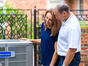 Professional AC System Inspection Technician inspecting multiple American Standard air conditioning units