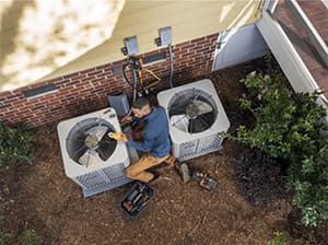 Air Conditioning Preventative Maintenance Service Technician performing HVAC diagnostics on an American Standard AC unit