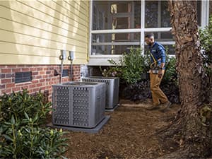 Professional AC System Inspection Technician inspecting multiple American Standard air conditioning units
