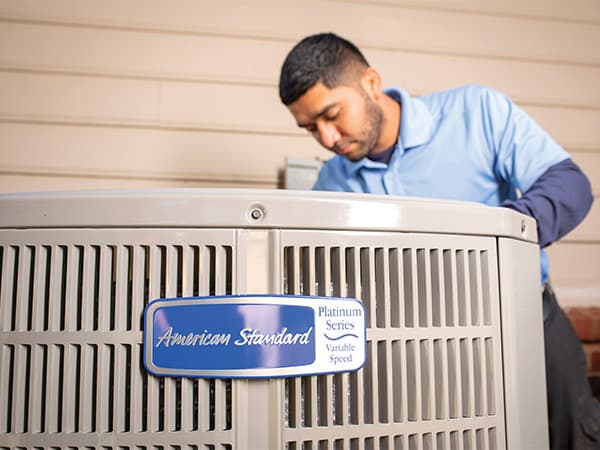 Professional AC Repair Service HVAC technician servicing an American Standard air conditioning unit