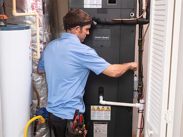 Heat Pump Repair and Service Mid-Cities Arlington & Surrounding Areas HVAC technician repairing an American Standard heat pump system