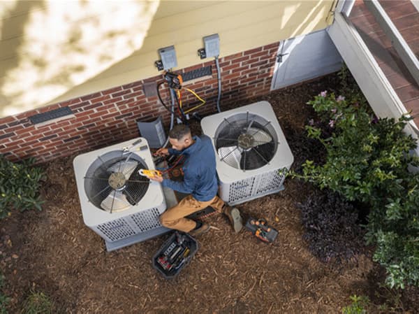 Air Conditioning Preventative Maintenance Service Technician performing HVAC diagnostics on an American Standard AC unit