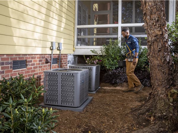 Professional AC System Inspection Technician inspecting multiple American Standard air conditioning units
